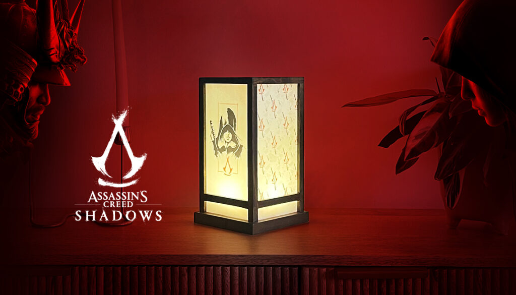 Lanterne Assassin's Creed Shadows au style japonais avec les protagoniste dessus, posé sur une commode au fond rouge
